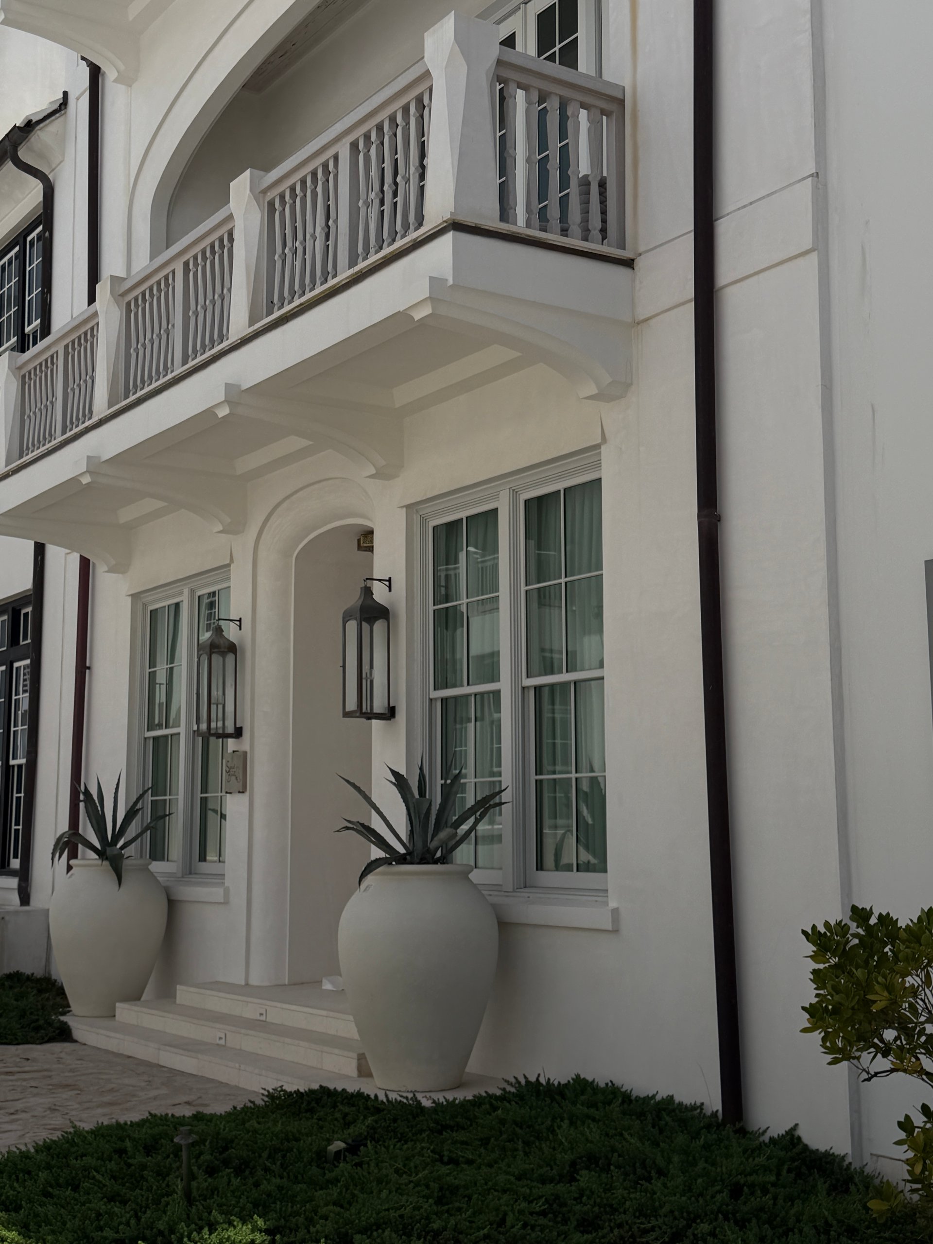 Quiet landscaped pedestrian street with white masonry homes in Alys Beach Florida