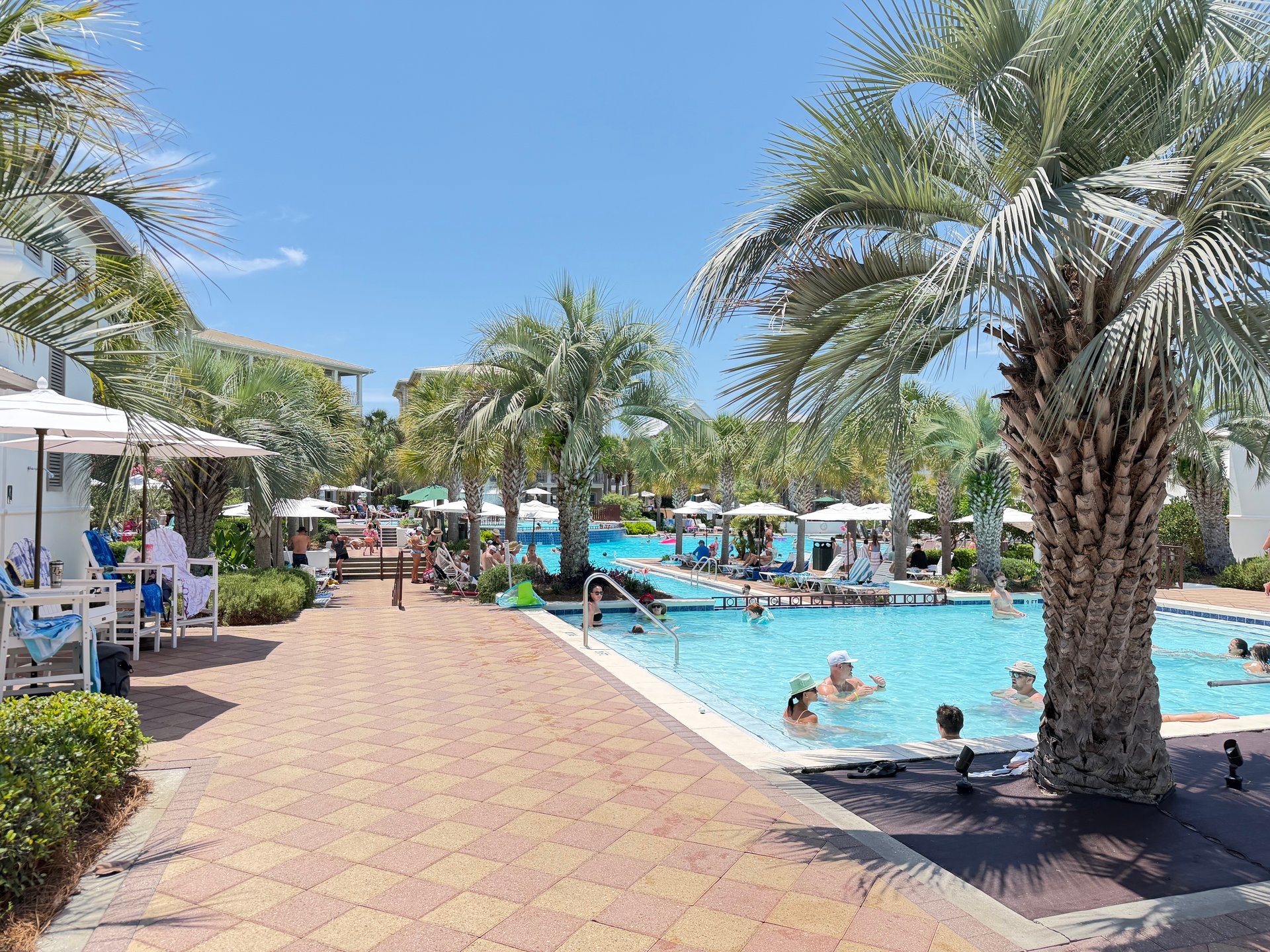 Seacrest Beach lagoon pool surrounded by palm trees and a pedestrian walkway