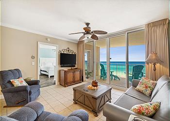 Furnished Gulf-view Panama City Beach condo living room with balcony access