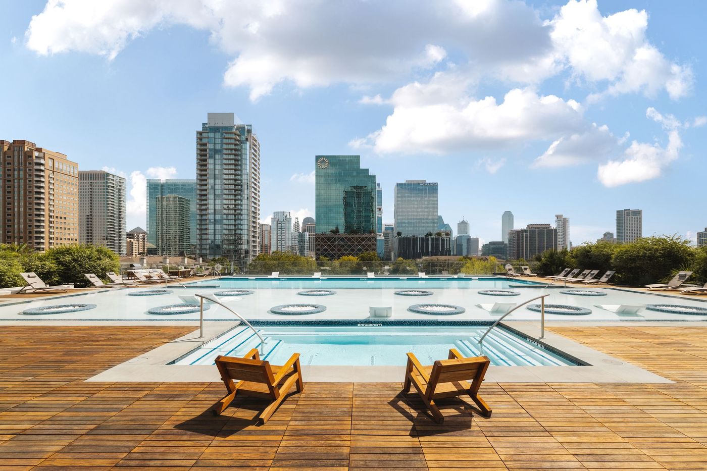 Pool deck at Bleu Ciel with cabanas and Uptown Dallas skyline