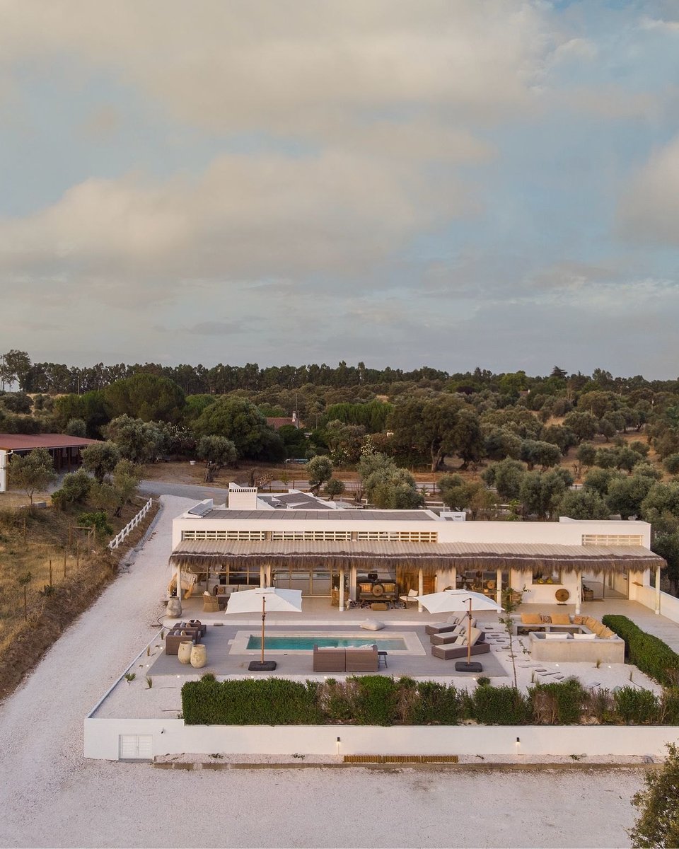 Aerial view of a contemporary single-story equestrian estate near Arraiolos, &Eacute;vora, with a natural stone pool and surrounding olive groves