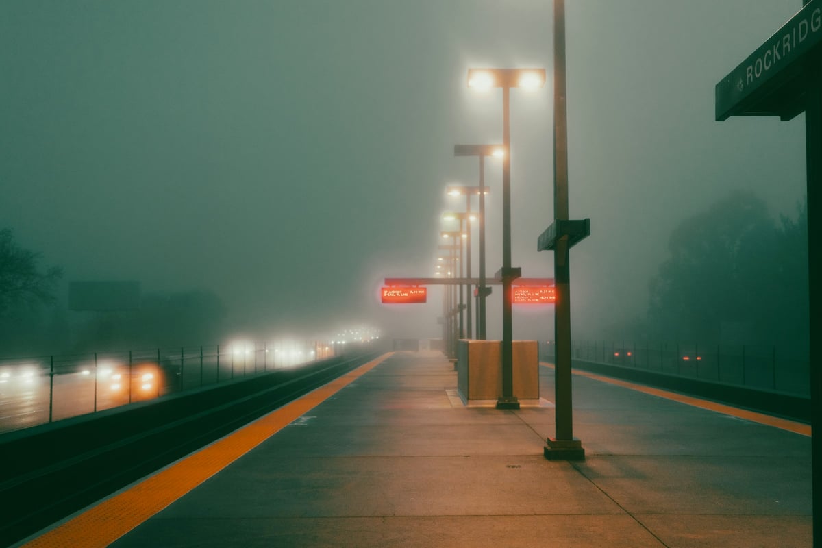 A foggy Oakland street at dusk under streetlights