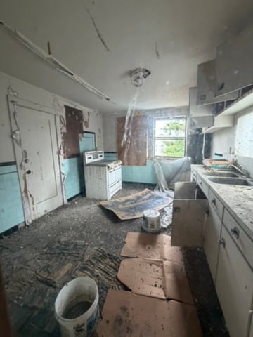 Kitchen at 964-966 York Street with a collapsed ceiling and pigeon damage from a long-running roof leak, Mission District San Francisco