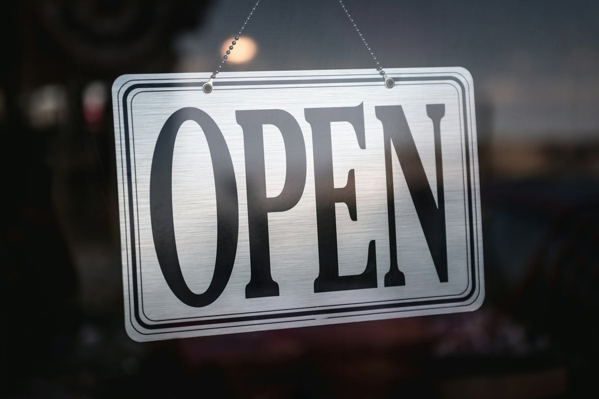 An open house sign hanging in a window