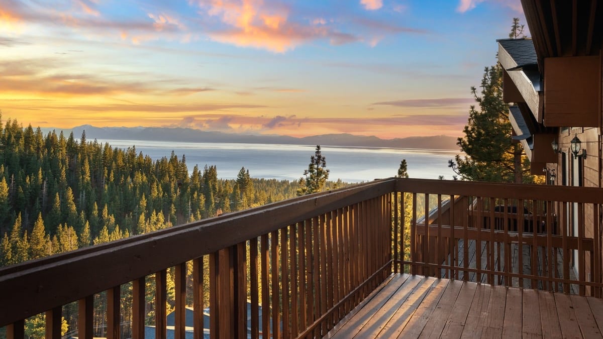Wood deck at sunset looking over the pines to Lake Tahoe from a Bitterbrush condominium