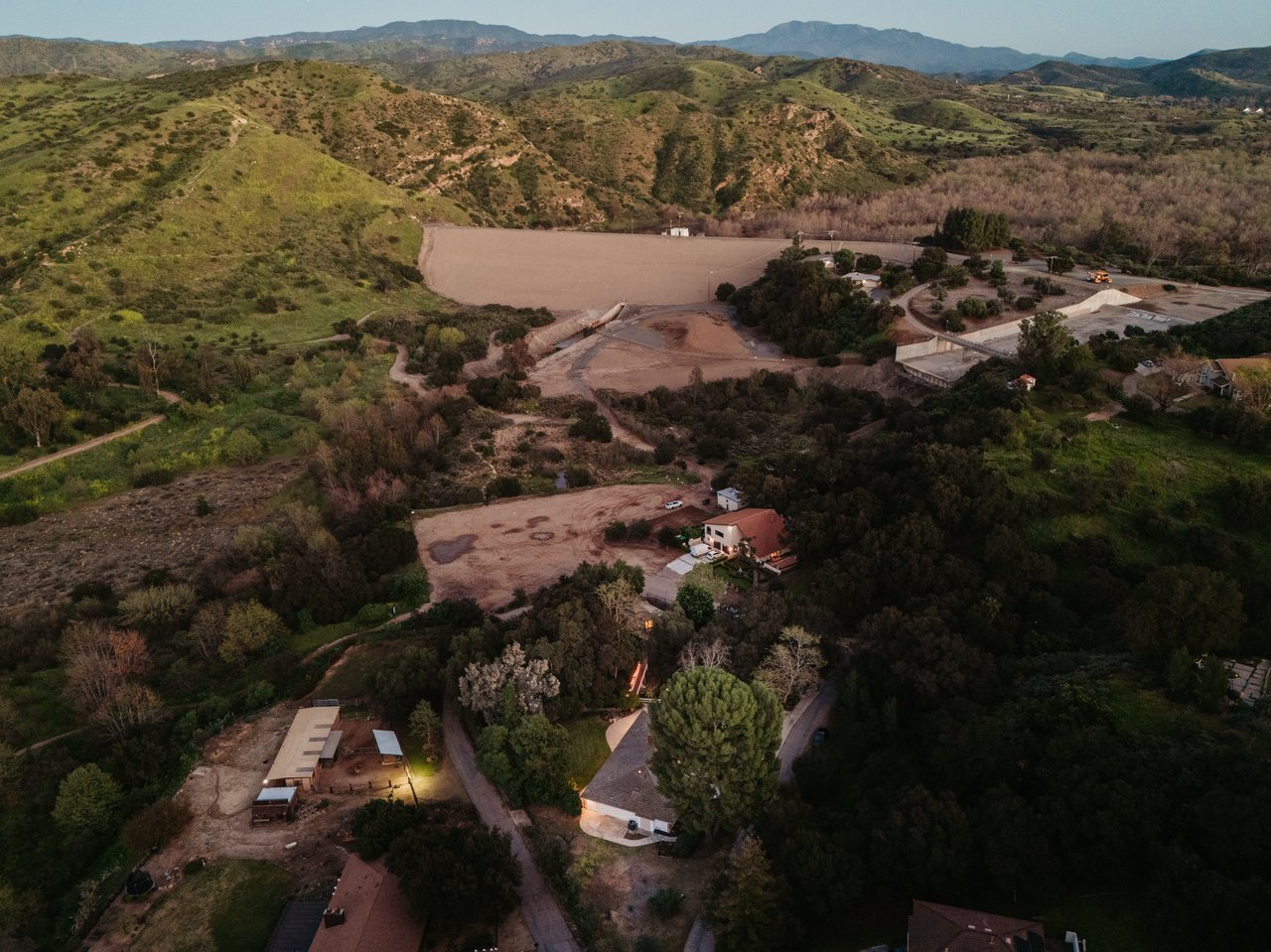 Aerial view of Orange Park Acres homes and wooded lots, with open hills and mountains beyond.