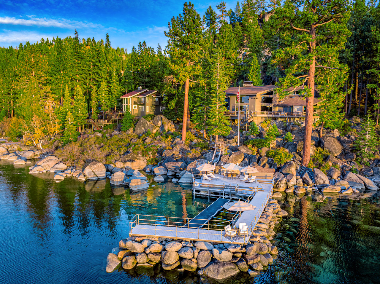 Waterfront homes among granite boulders, with a long dock extending into the lake.