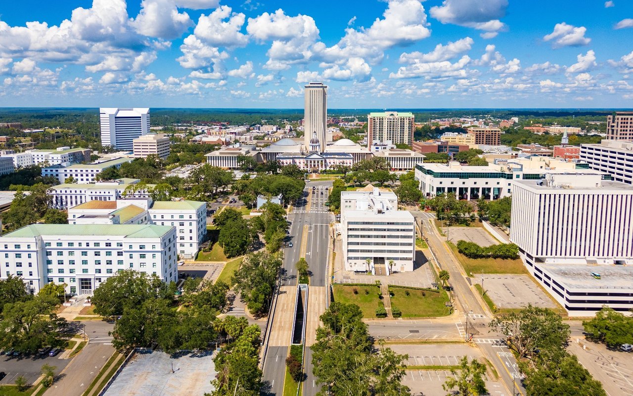 Aerial view of downtown Tallahassee with the Florida State Capitol tower and surrounding buildings.