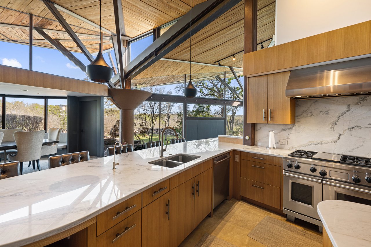 Kitchen work wall with Wolf range, Sub-Zero refrigeration and quartzite counters, 4002 Tyx Trail, Spicewood, Texas.