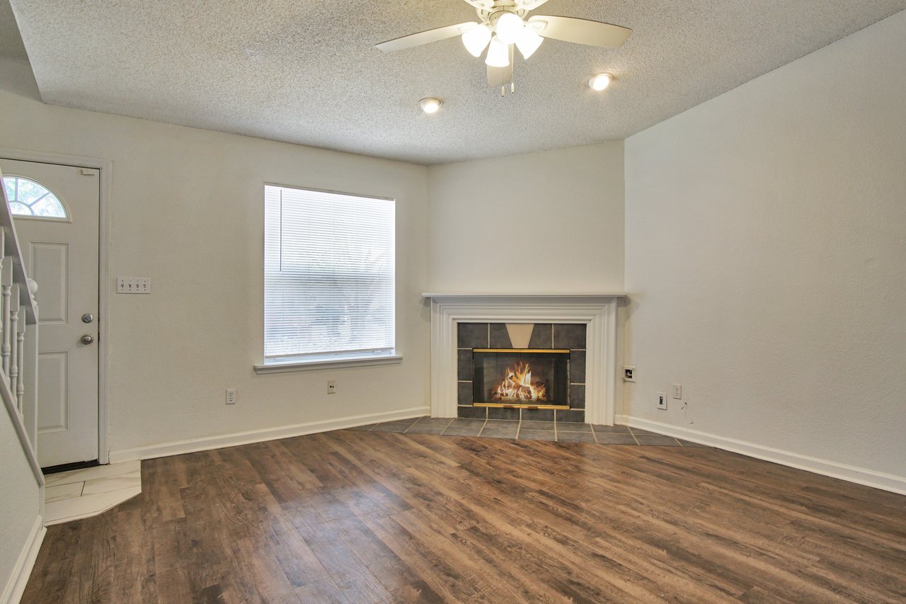 A cozy living room featuring a fireplace and elegant hardwood floors, creating a warm and inviting atmosphere.