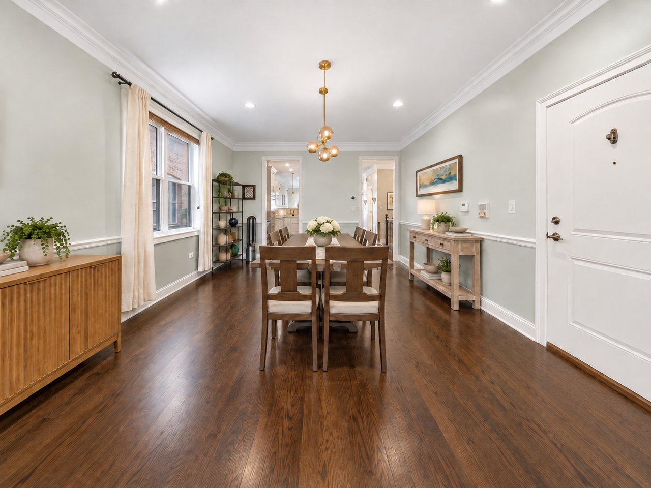 Dining room view toward the front door, with sideboard and wood floors