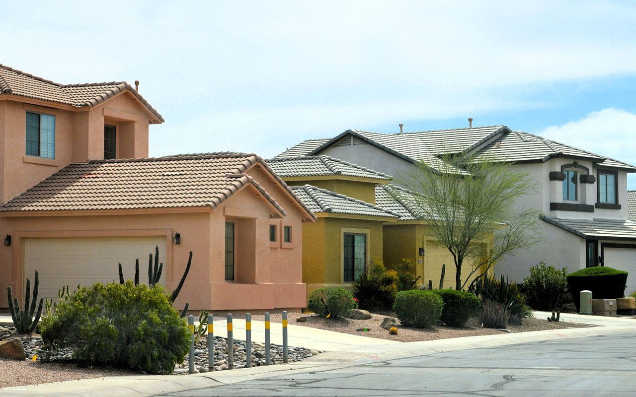 Southwestern homes with tiled roofs and desert landscaping along a residential street.