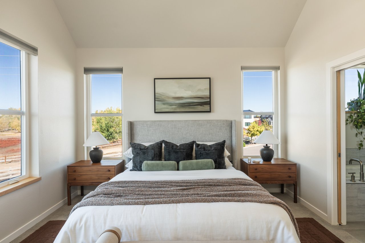 Primary bedroom with the bed centered between two windows and matching nightstands