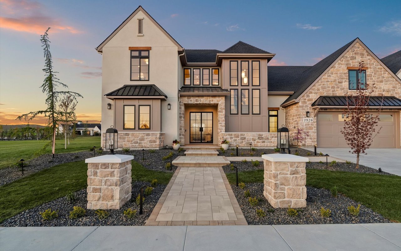 Front exterior of the home - steeply pitched roofs, and a mix of stucco, stone and black metal