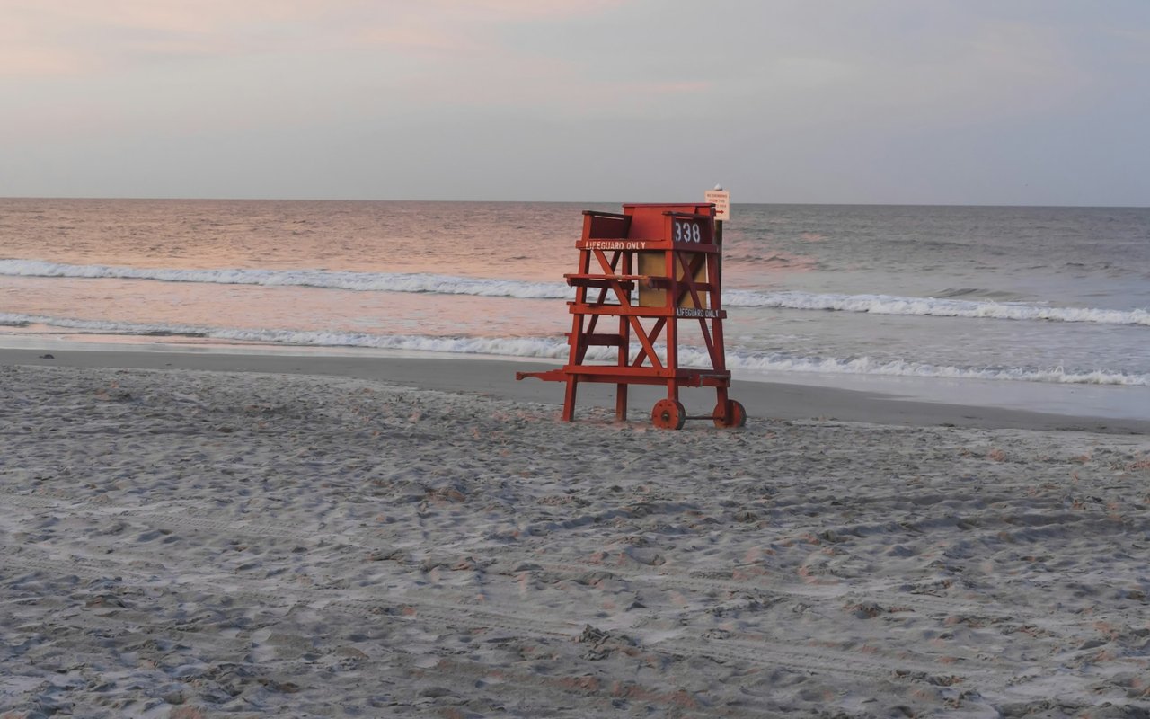 Beach shoreline with waves and a red lifeguard tower marked 338.