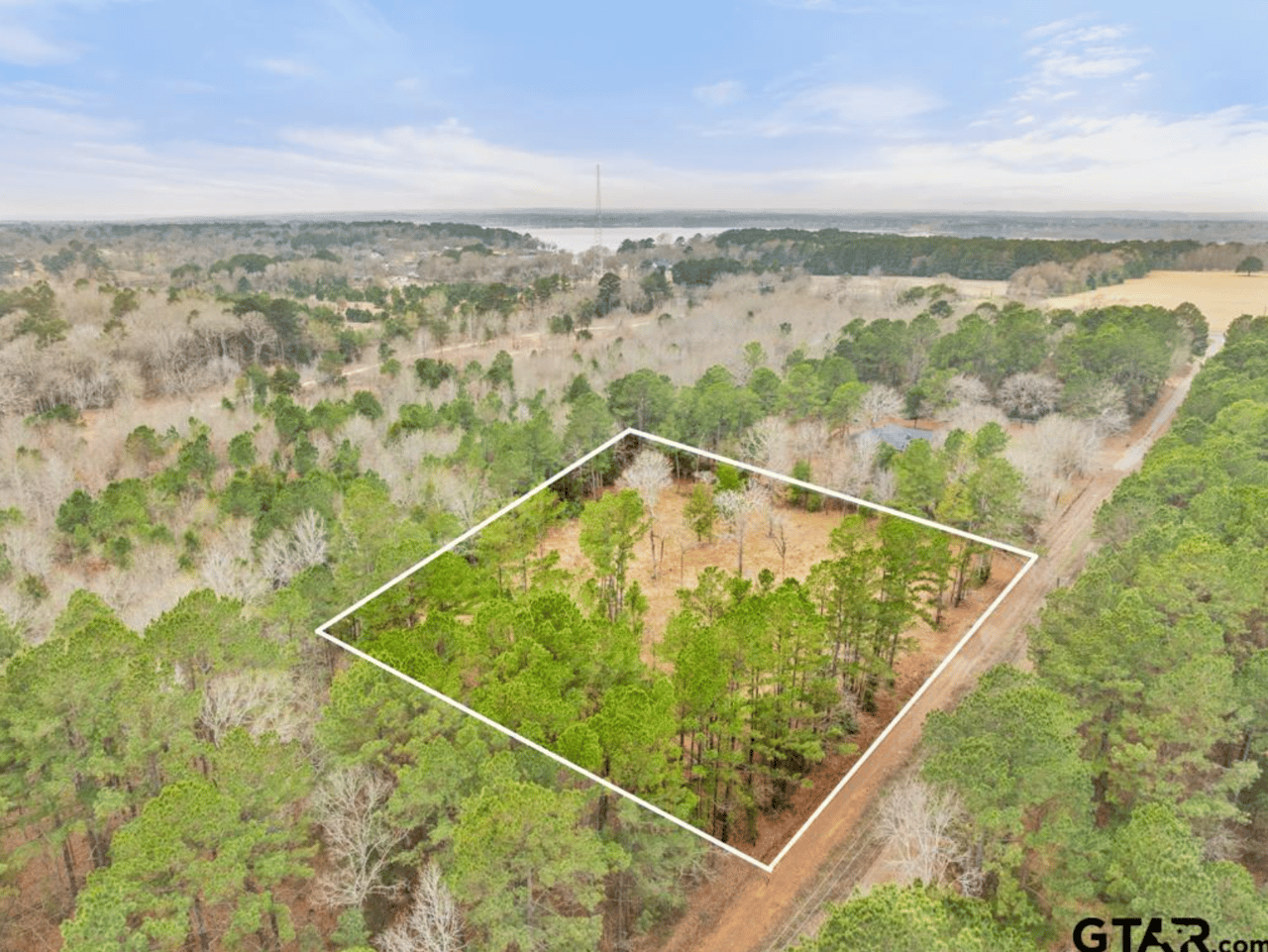 Aerial view of wooded 2.23-acre land lot for sale at 268 County Road 3607, Bullard TX, with property boundary lines and lake visible in the distance — East Texas land for sale near Lake Palestine.