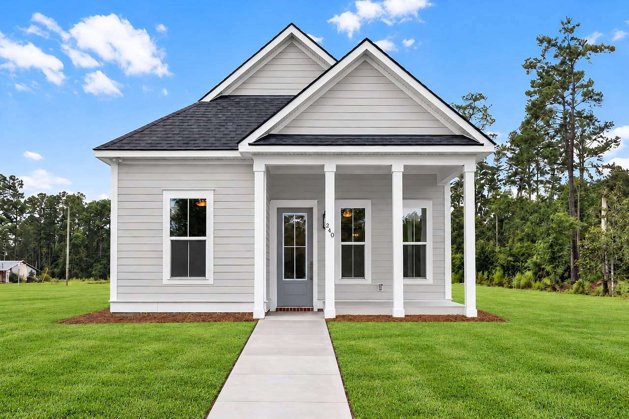 Light gray home with a covered porch, white columns, and a walkway across the lawn.
