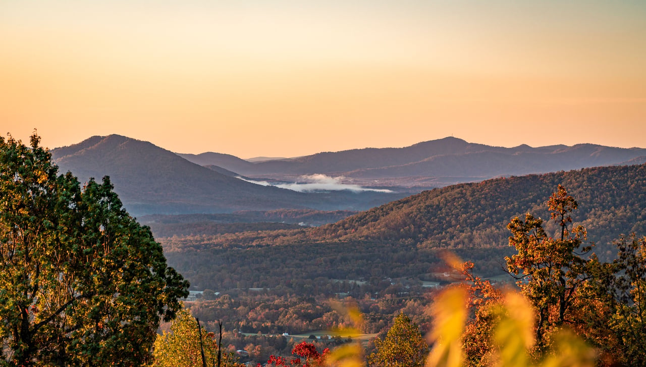 Autumn mountain ridges and forested North Georgia valleys under a warm golden-hour sky.
