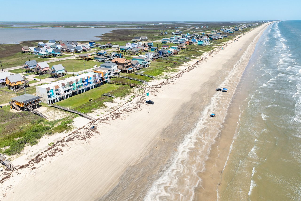 Beachfront homes along Surfside Beach, Texas with sand and ocean in view