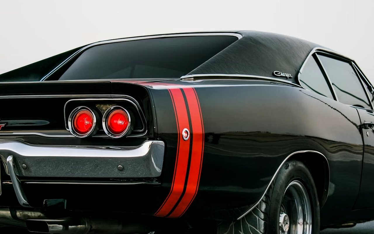 Black classic Dodge Charger with red racing stripes and round taillights.
