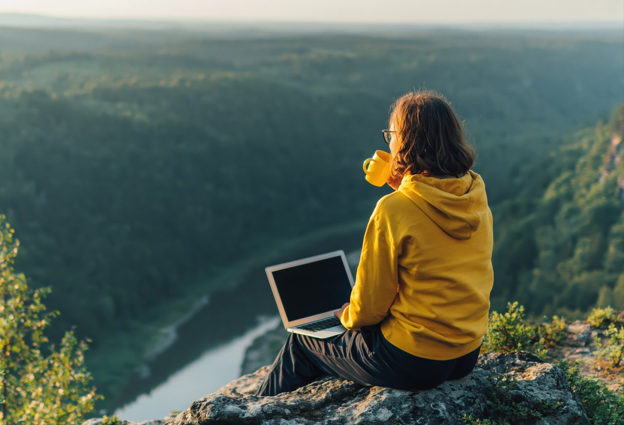 Resident enjoying remote work with panoramic Blue Ridge Mountain views from River Green Condominiums in Franklin, North Carolina.
