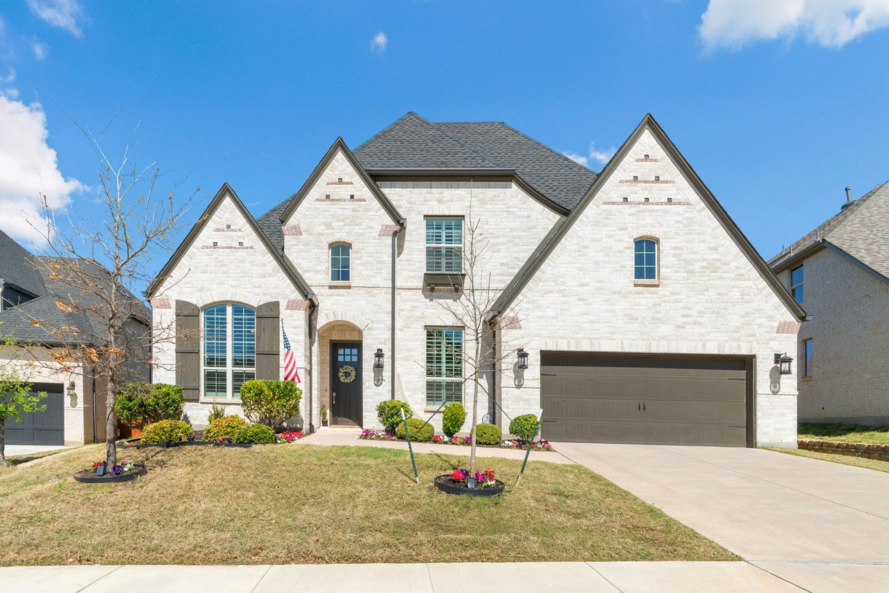 Modern brick home with gabled roof, two-car garage, and landscaped front yard in Lantana North Texas
