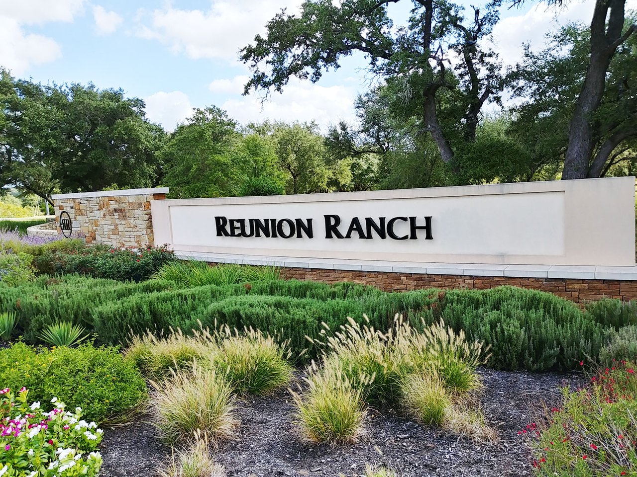 Reunion Ranch neighborhood entrance sign amid landscaped greenery.