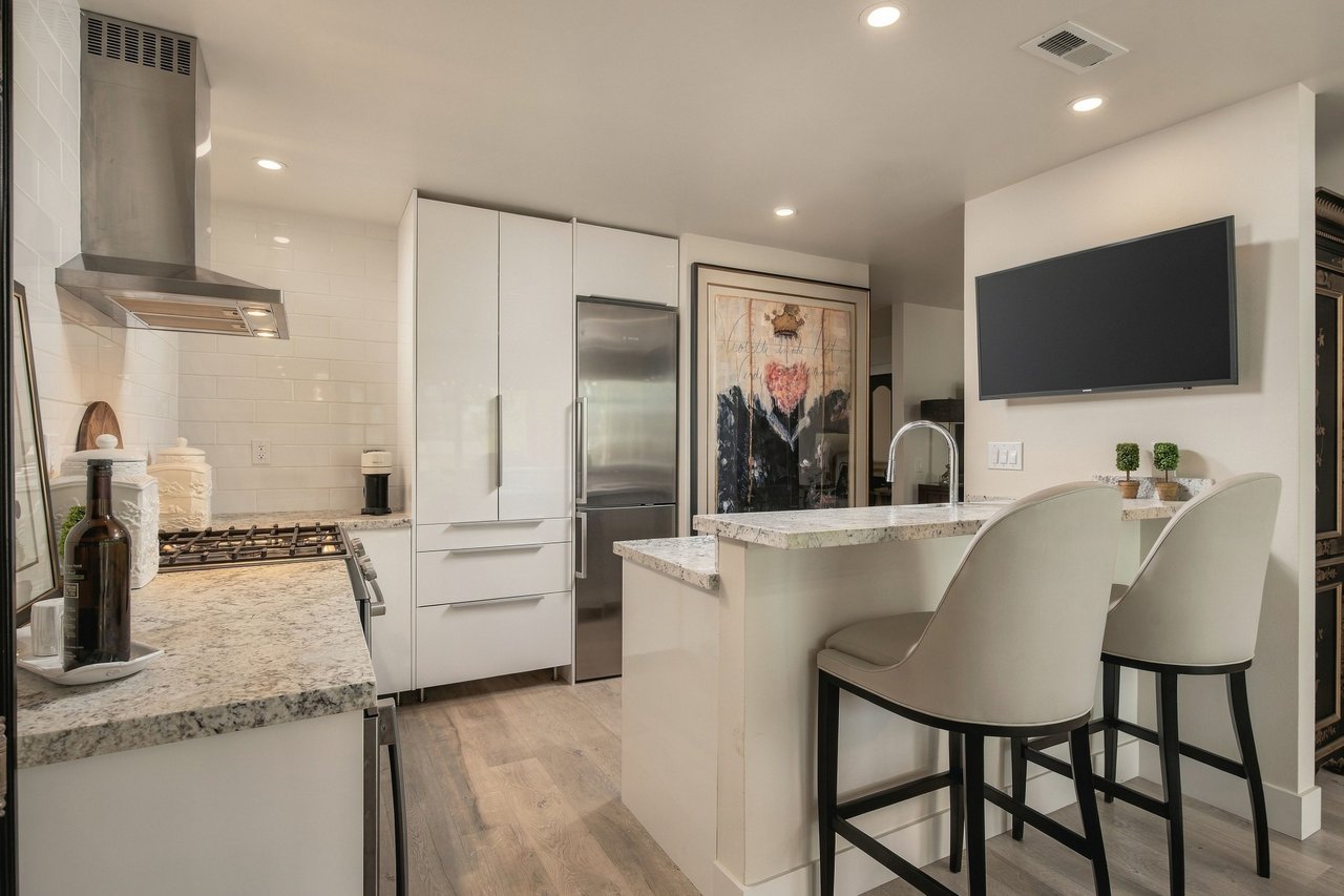 Renovated kitchen with breakfast bar seating and stainless steel appliances in a Rossmoor Walnut Creek condo for sale
