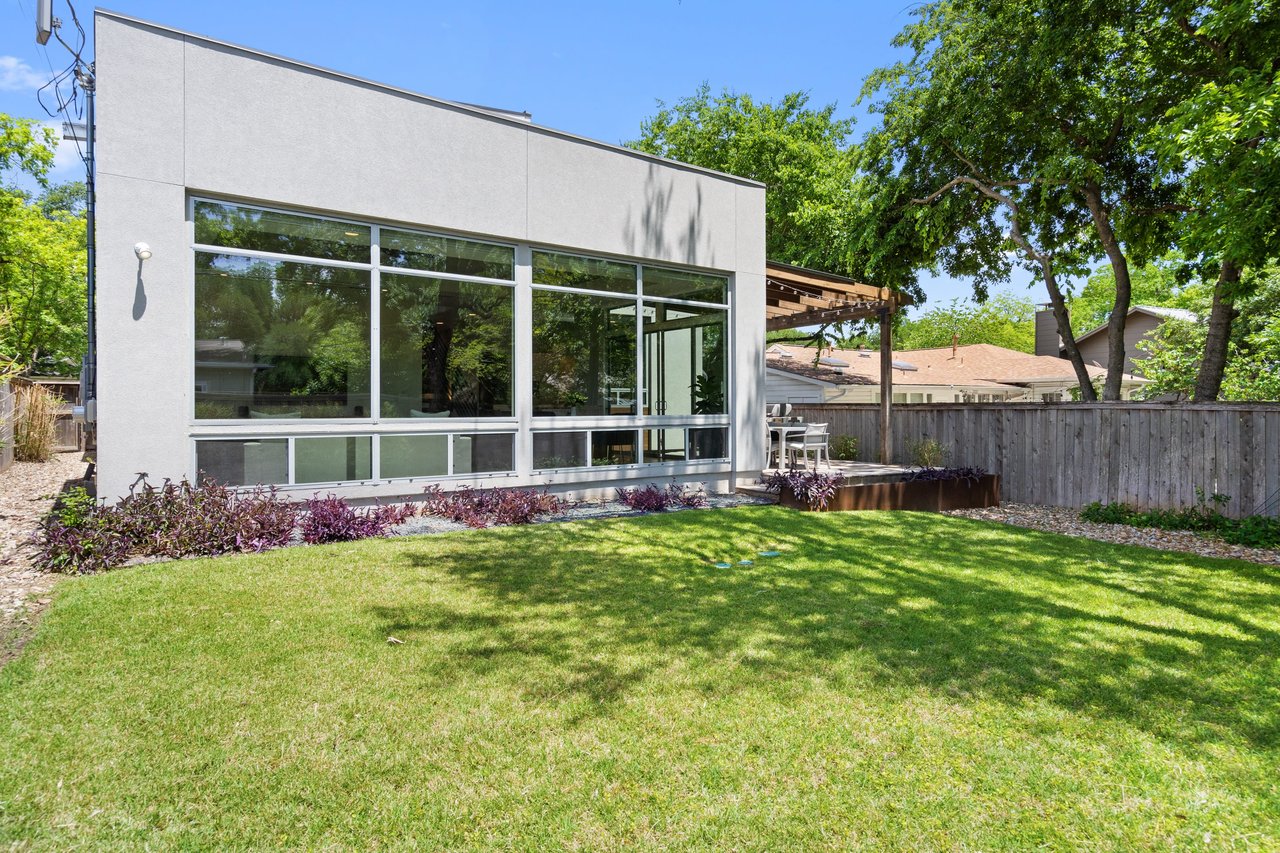 Rear elevation of 34 Margranita Crescent, Tarrytown, Austin, TX, with a flat roof and a wall of windows, built by Mark Dawson Homes.