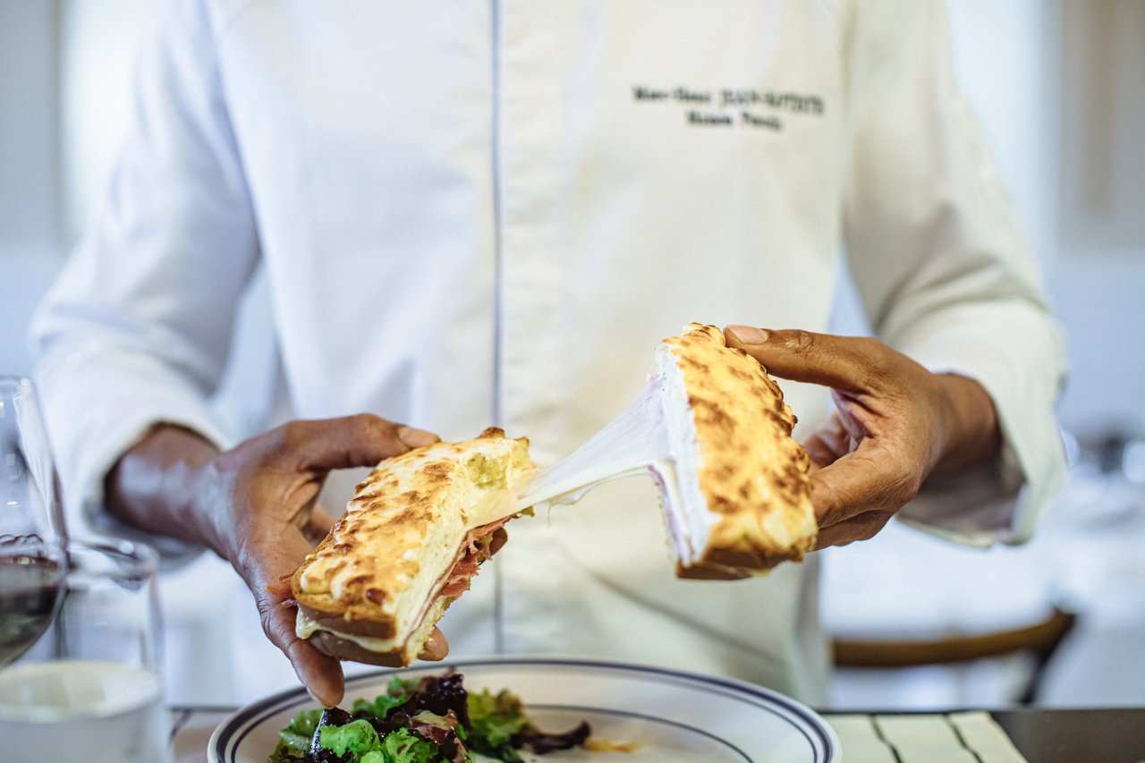 Toasted cheese-filled bread is pulled apart over a plate of salad.
