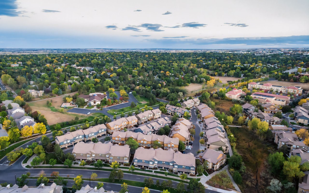 Aerial view of a suburban neighborhood with winding streets and autumn-colored trees.