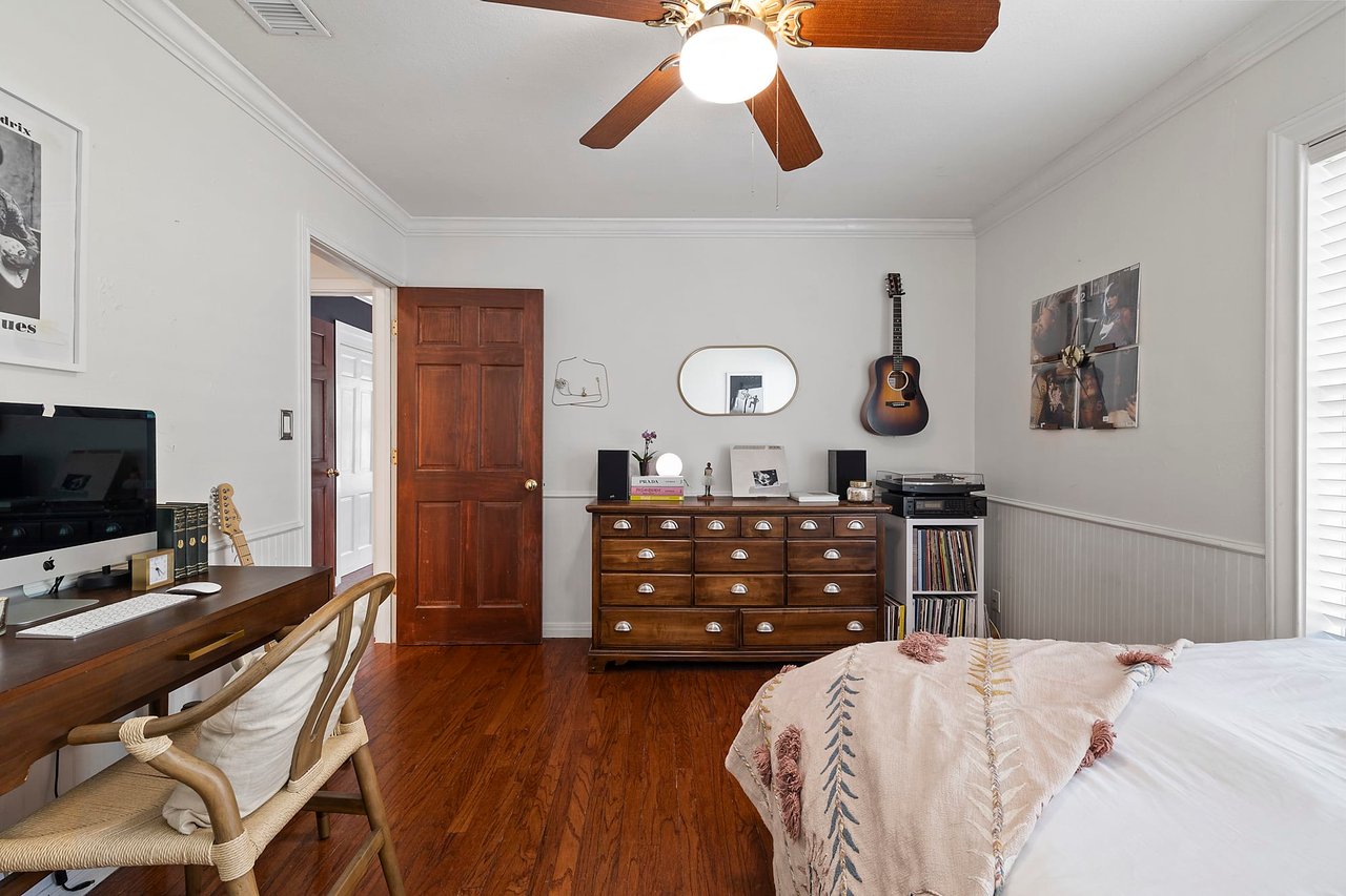 Bedroom with original wood floors and an antique dresser, Tarrytown, Austin.