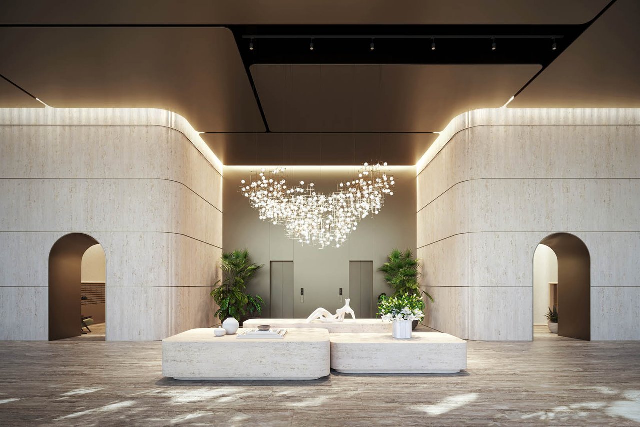 1428 Residences lobby with a sculptural stone reception desk and branching chandelier.