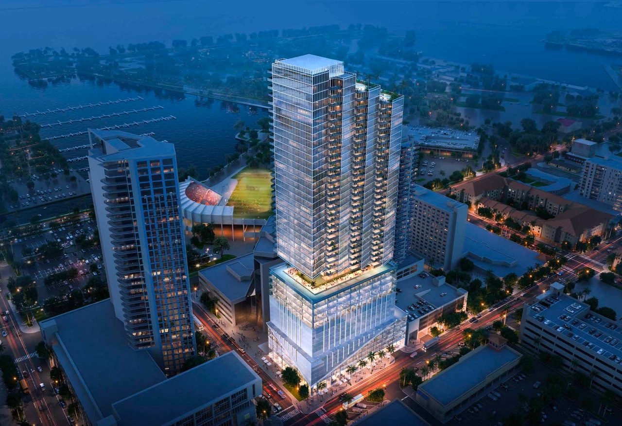 Rendering of a glass residential tower rising above downtown, with waterfront and marinas behind it.