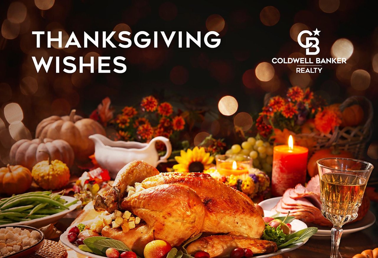 A beautifully set Thanksgiving dinner table with warm lighting, seasonal décor and a roasted turkey perfect for a holiday themed luxury real estate New Canaan CT.