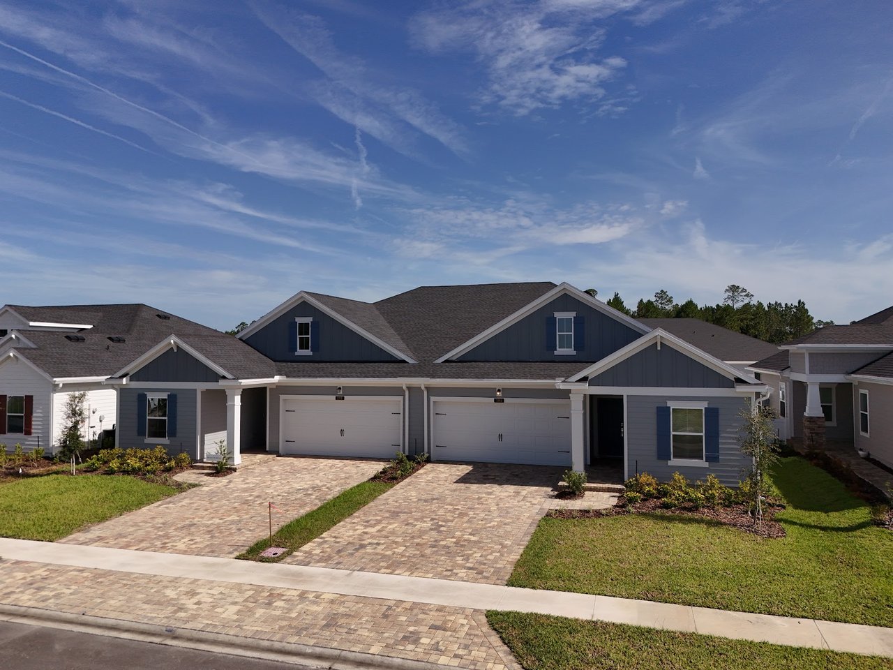 Attached gray homes with white-trimmed two-car garages and paved driveways.