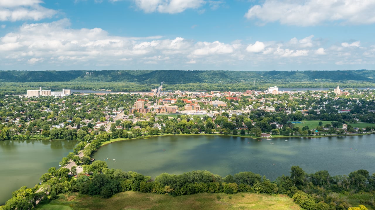 Aerial view of Winona, Minnesota, featuring the Mississippi River, surrounding bluffs, and the charming historic downtown area.