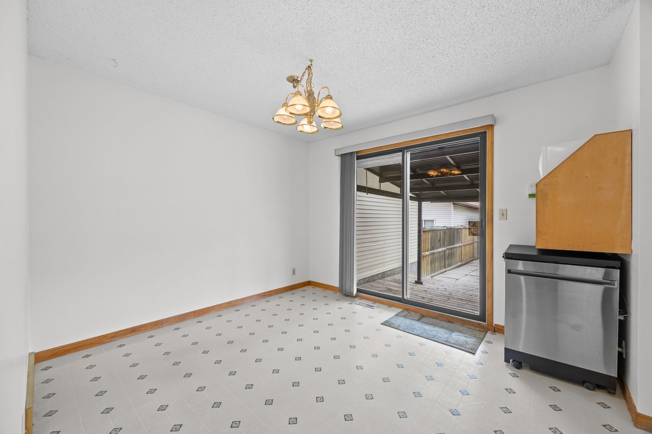 Empty dining area with patterned tile floors, a chandelier, and sliding glass doors to a covered patio.