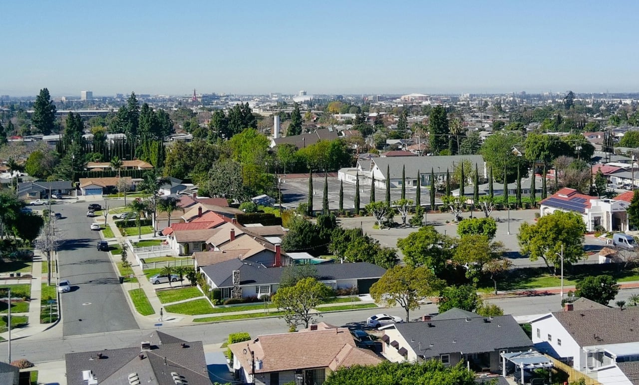Aerial view of Guaynabo homes and tree-lined streets with the city skyline beyond.