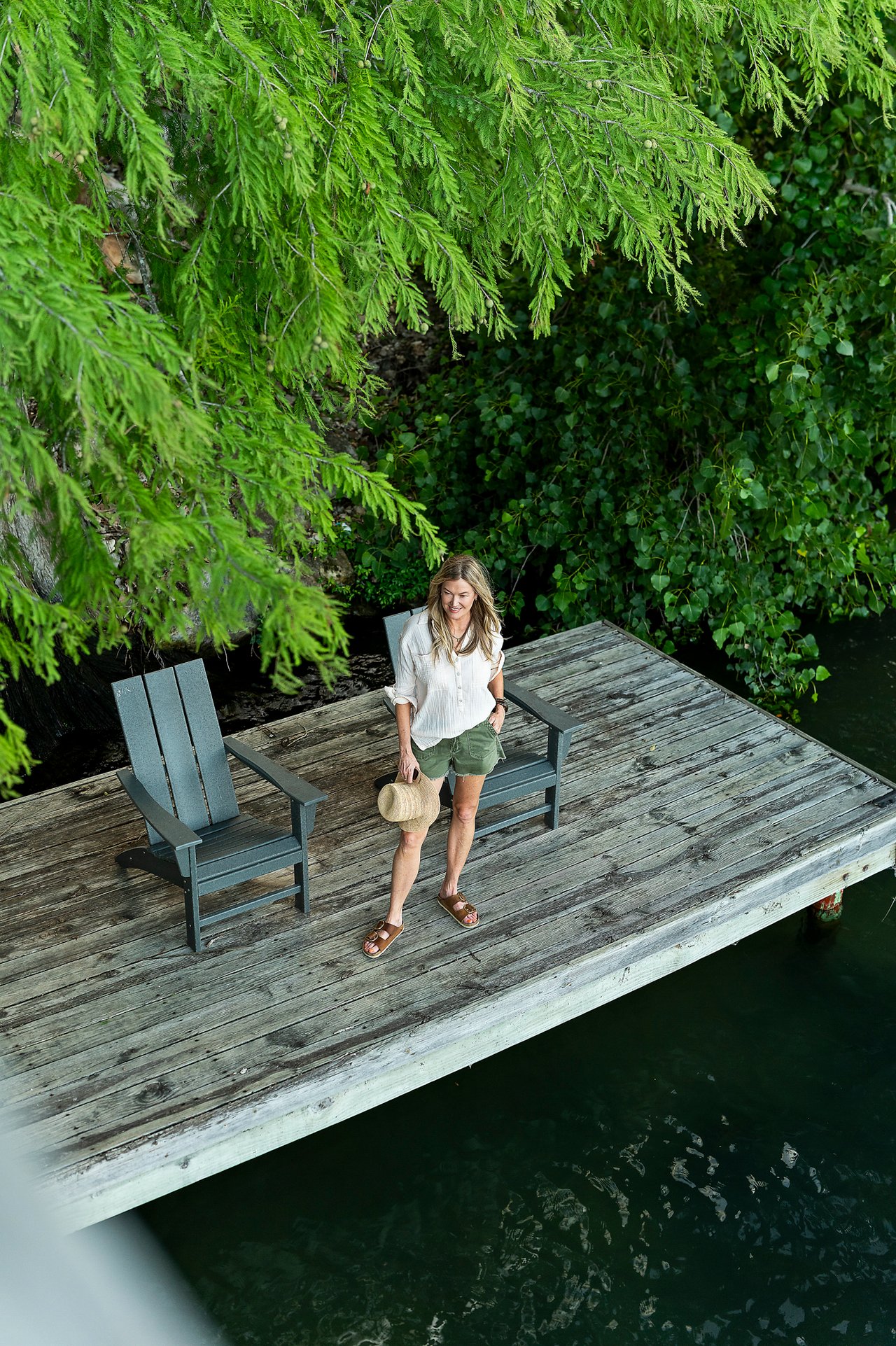Aerial view of the boat dock and sun deck along the cypress shoreline of Lake Austin at 2403 Big Horn Drive, Austin.