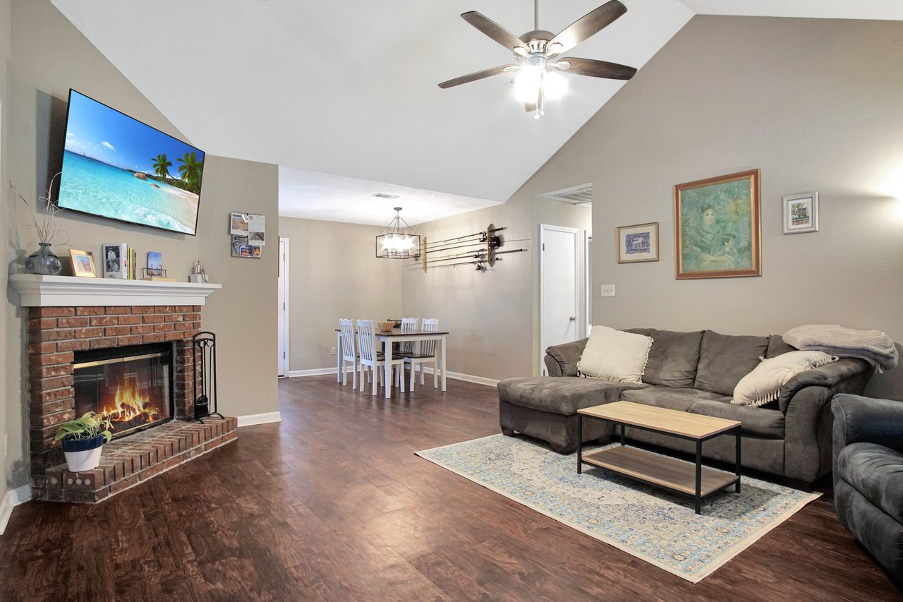 A cozy living room featuring a fireplace and a flat-screen TV, creating a warm and inviting atmosphere.