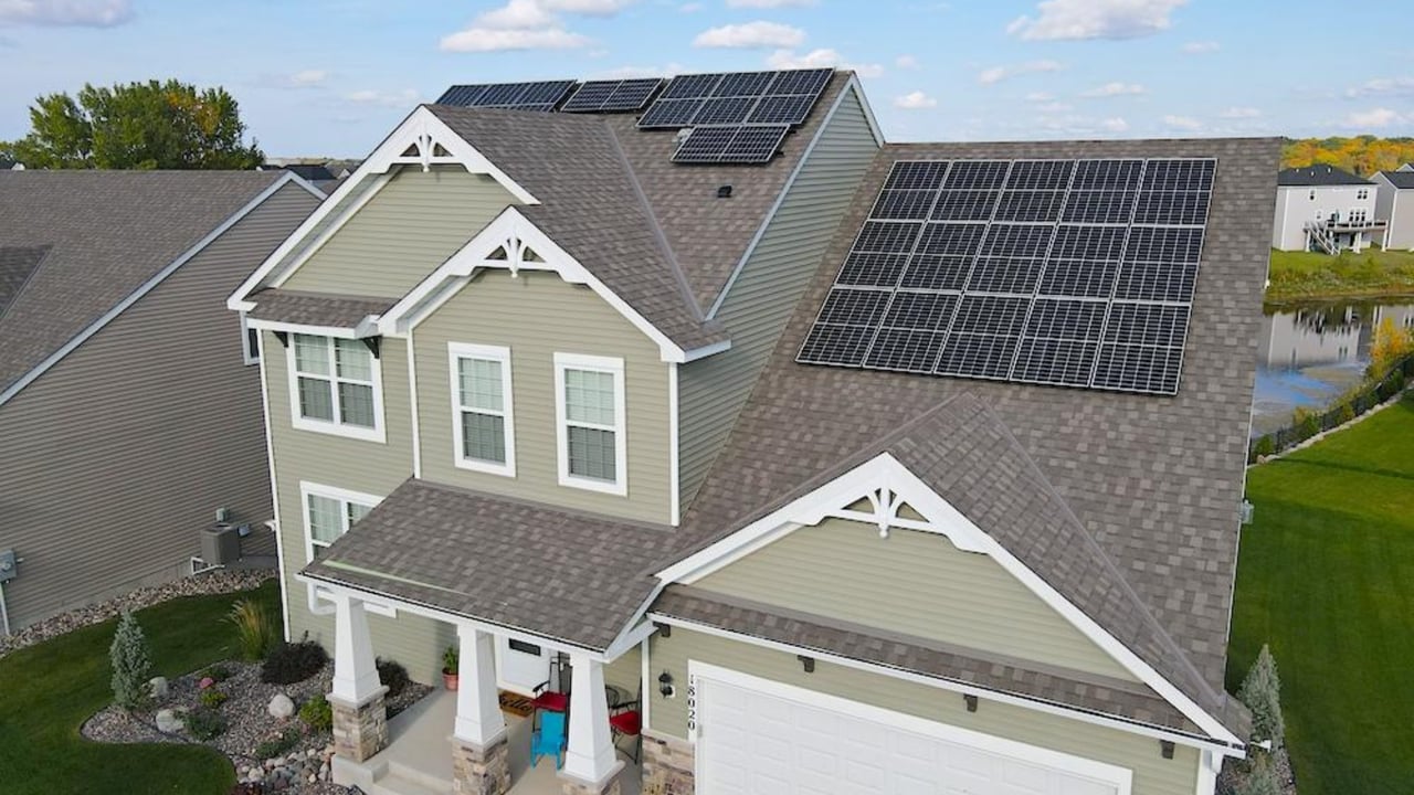 Two-story home with solar panels covering much of its roof, viewed from above.