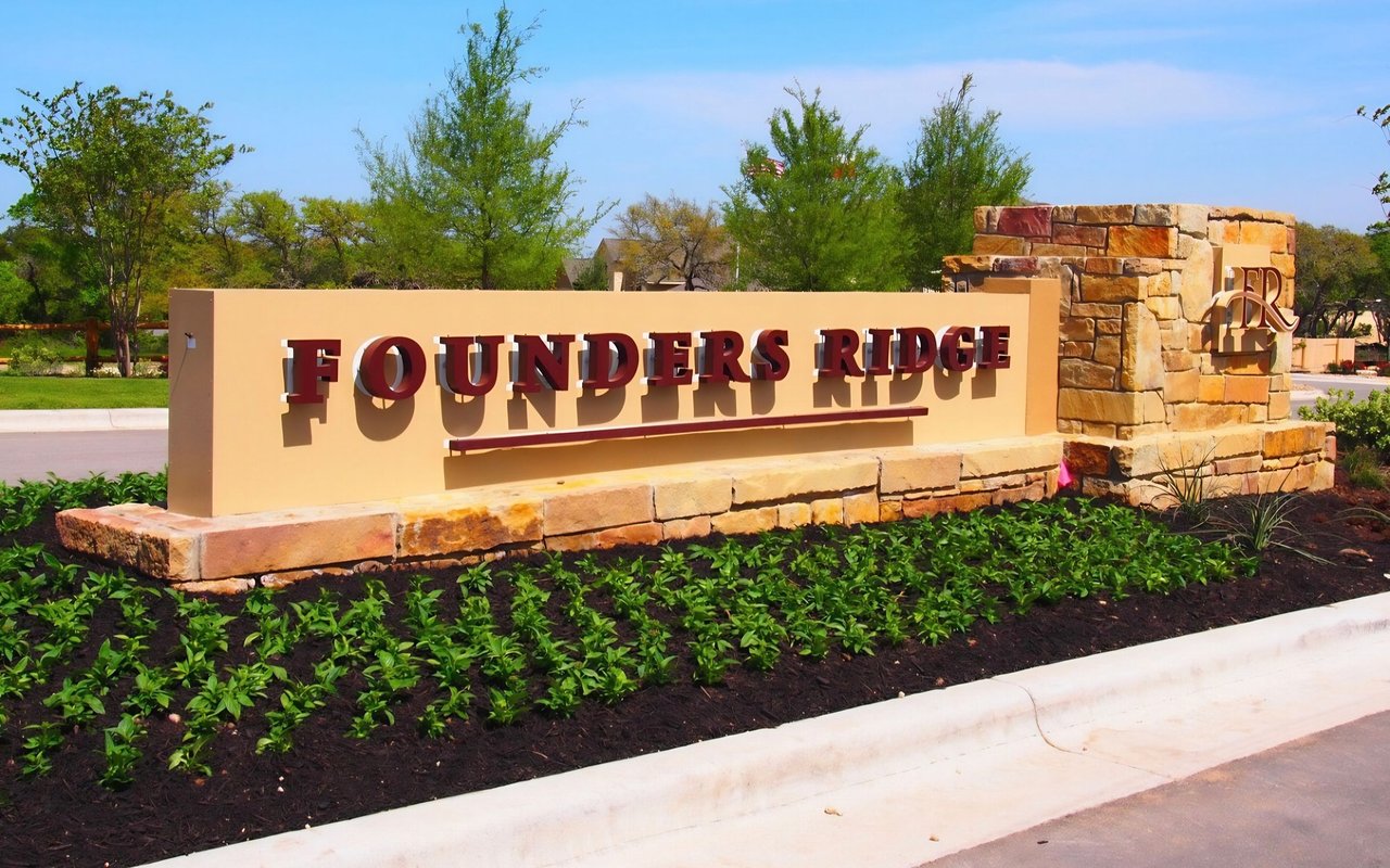 Founders Ridge entrance sign with a stone pillar and landscaped planting bed.