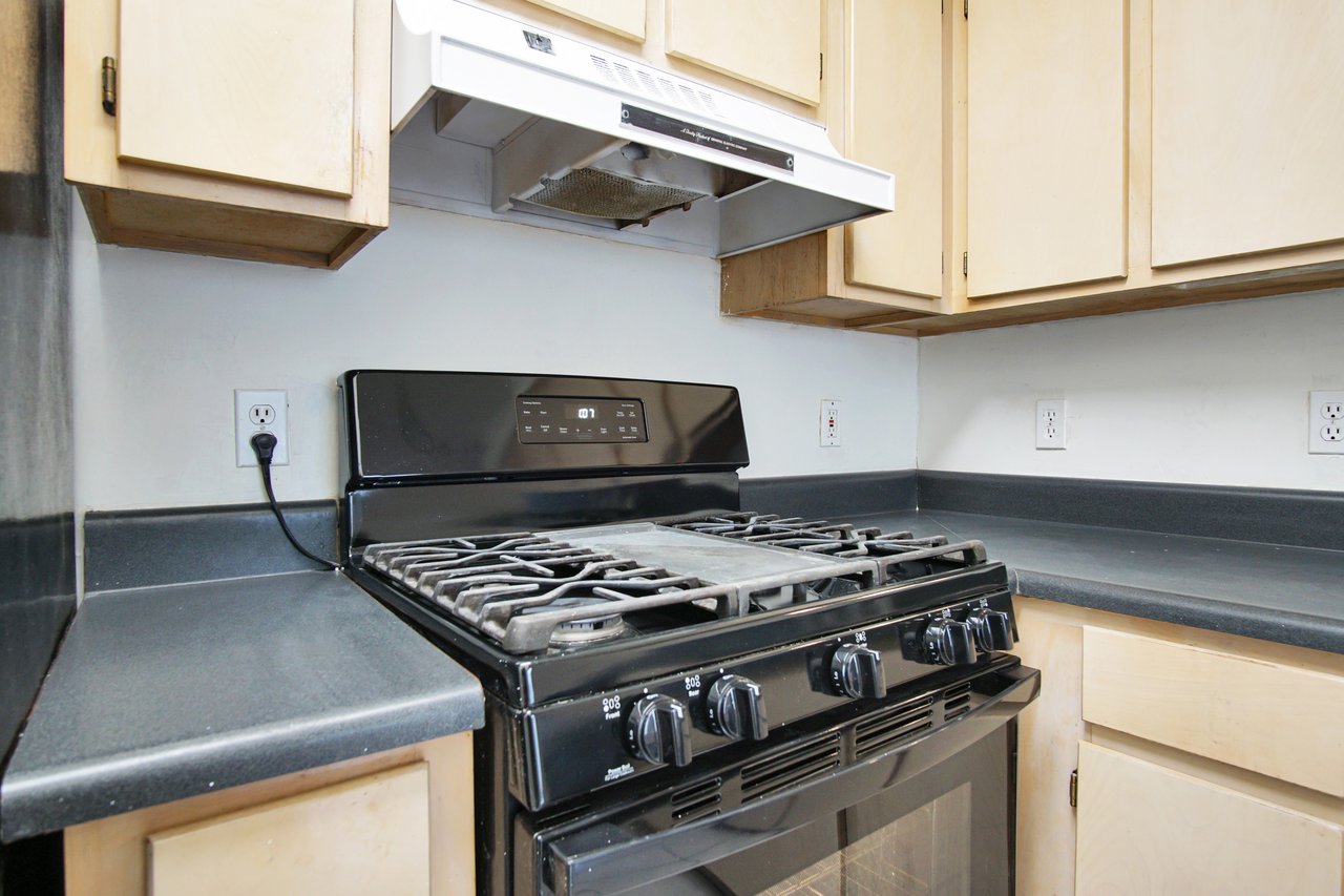 A modern kitchen featuring a stove and oven, showcasing a clean and organized cooking space.