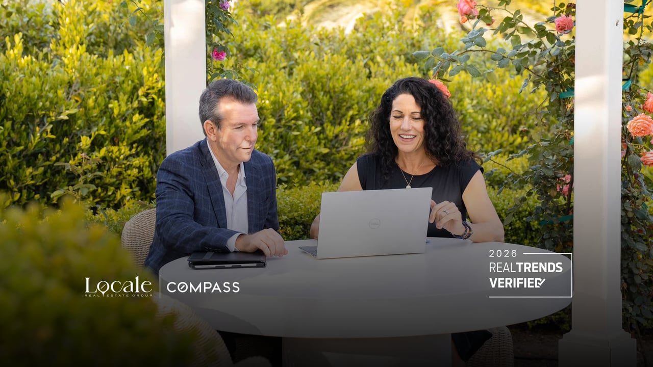 Real estate professionals Jon Perkins and Michelle Heckman of Locale Group at Compass, standing together in a sophisticated, professional setting representing Santa Barbara and Montecito real estate.