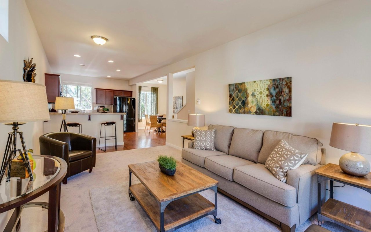 A cozy living room with a light grey sofa and a dark brown leather armchair.