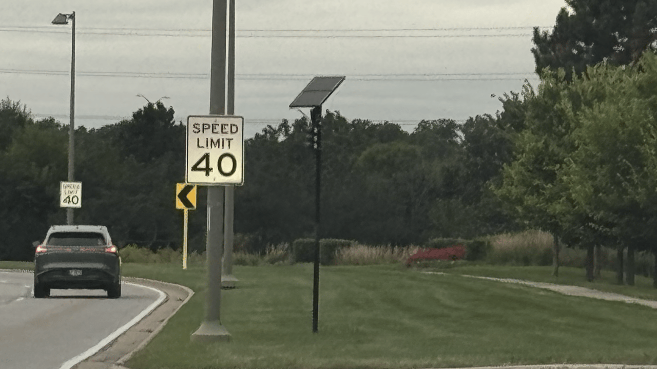 Municipal police perimeter license plate reader camera positioned along a public roadway corridor in Warrenville, Illinois.