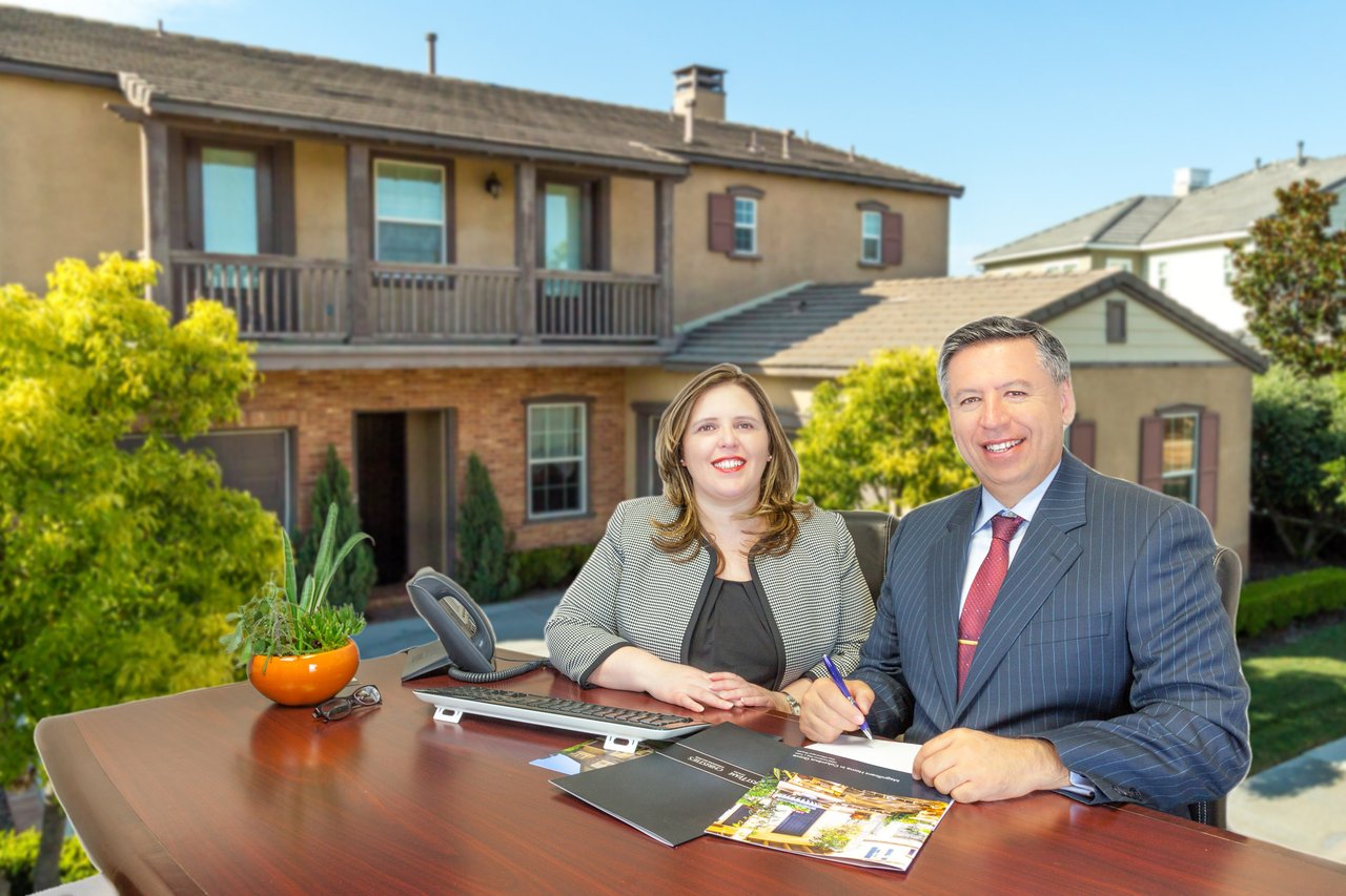 Martin and Laura Uribe working at the office with a house as background