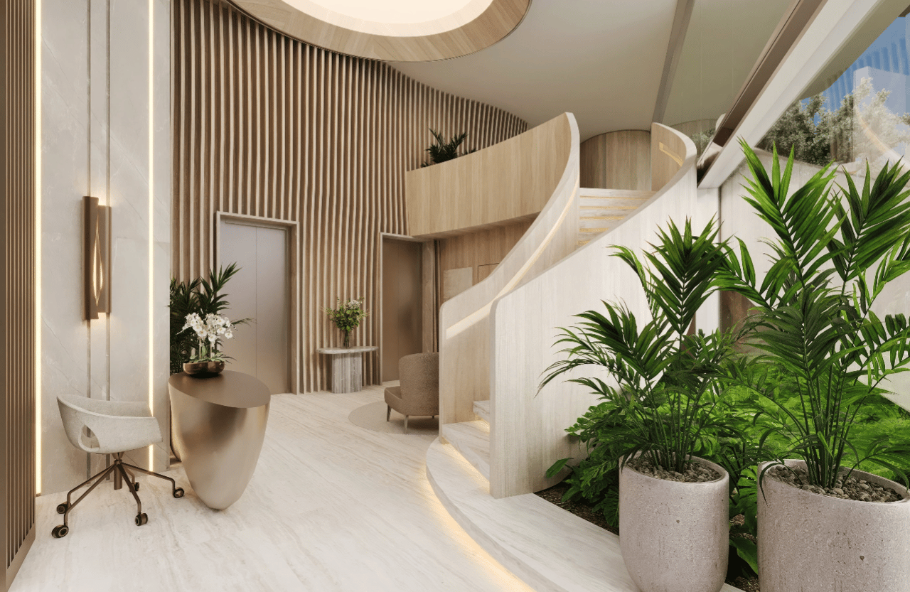 Luxury condo lobby with a curved staircase, pale stone finishes, and tropical plants.