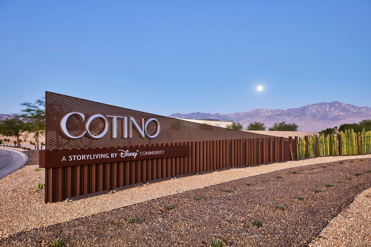 Cotino community entrance sign with desert landscaping and mountains in the background.